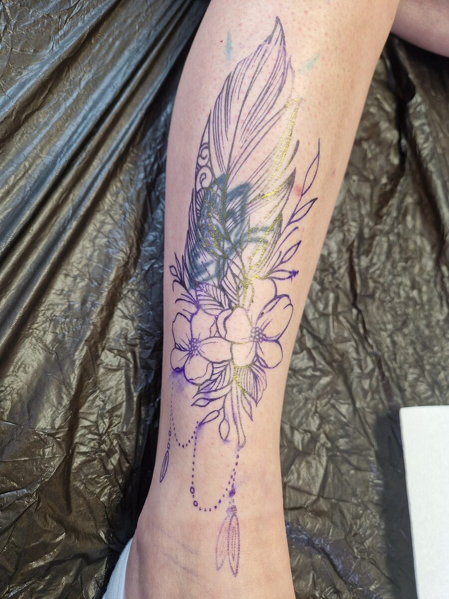 Vorlage für ein Tattoo-Design auf Bein mit Federn, Blumen und Perlenketten, violette Skizze.